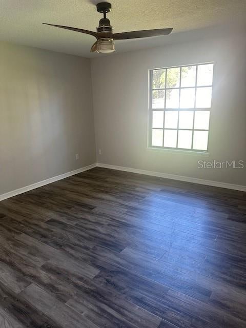 unfurnished room featuring dark wood-type flooring, ceiling fan, and a textured ceiling