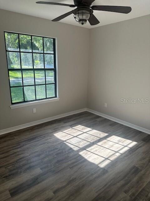 unfurnished room with ceiling fan and dark hardwood / wood-style floors