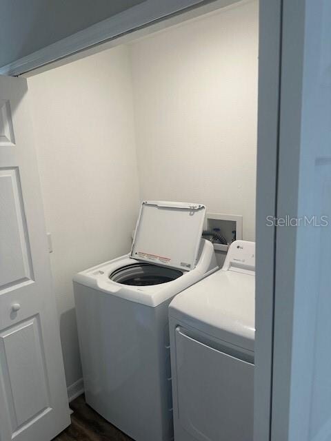 laundry area featuring independent washer and dryer and dark hardwood / wood-style flooring