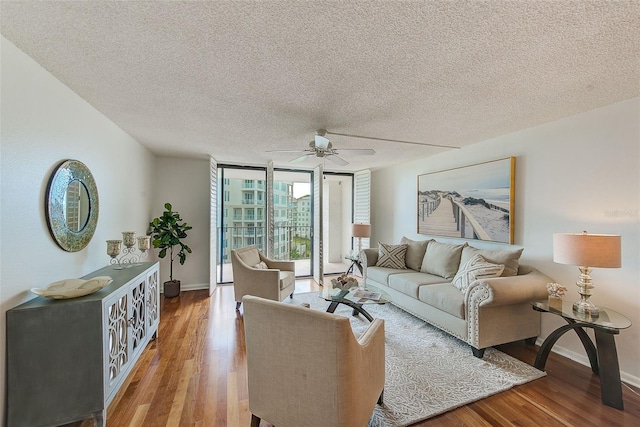 220 Belleview Blvd Unit 802, Belleair, FL 33756 - living area featuring wood finished floors, ceiling fan, baseboards, a textured ceiling, and expansive windows