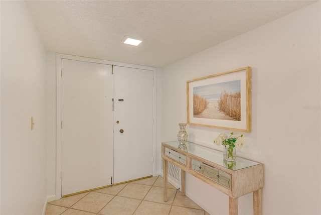 tiled entrance foyer featuring a textured ceiling