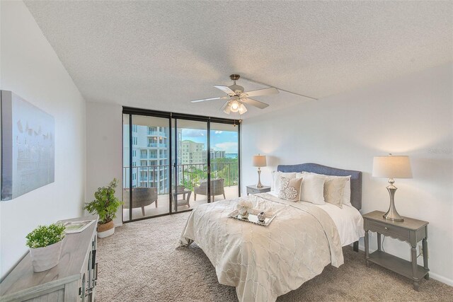 bedroom with floor to ceiling windows, a textured ceiling, carpet flooring, ceiling fan, and access to exterior