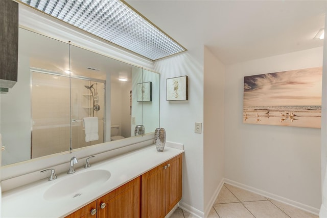 bathroom featuring a shower with door, vanity, tile patterned floors, and toilet