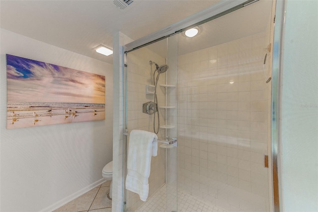 bathroom featuring a shower with door, tile patterned floors, and toilet