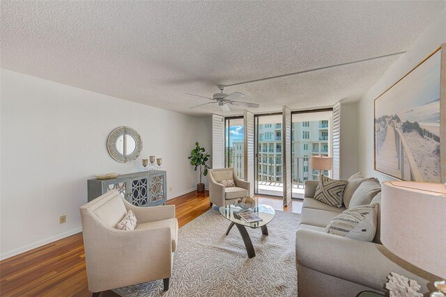 living room with hardwood / wood-style flooring, a textured ceiling, ceiling fan, and floor to ceiling windows