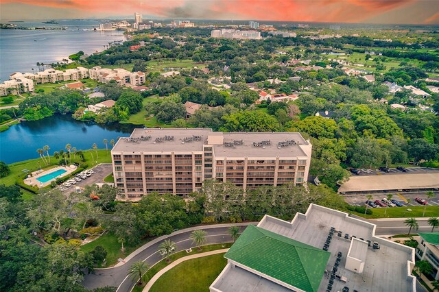 aerial view at dusk featuring a water view