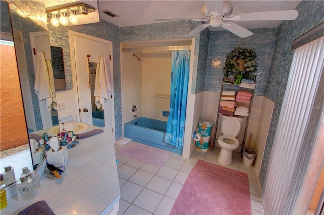 full bathroom with tile patterned floors, toilet, shower / bath combo with shower curtain, vanity, and ceiling fan