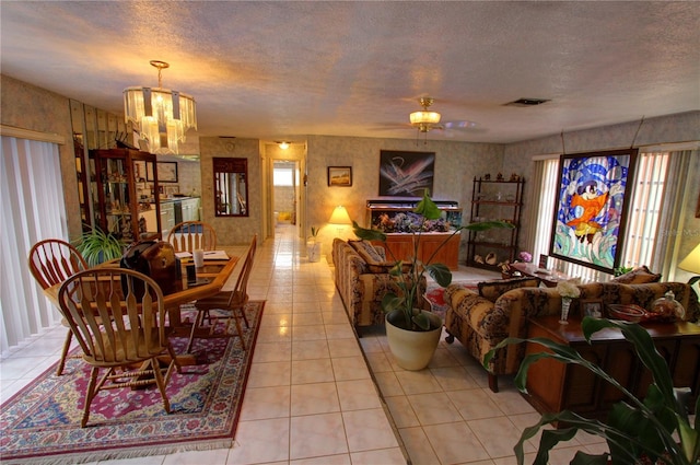 dining room with a textured ceiling, light tile patterned floors, and an inviting chandelier