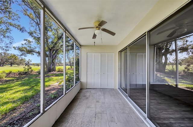 unfurnished sunroom featuring ceiling fan