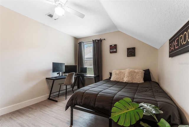 bedroom featuring vaulted ceiling, wood-type flooring, ceiling fan, and a textured ceiling