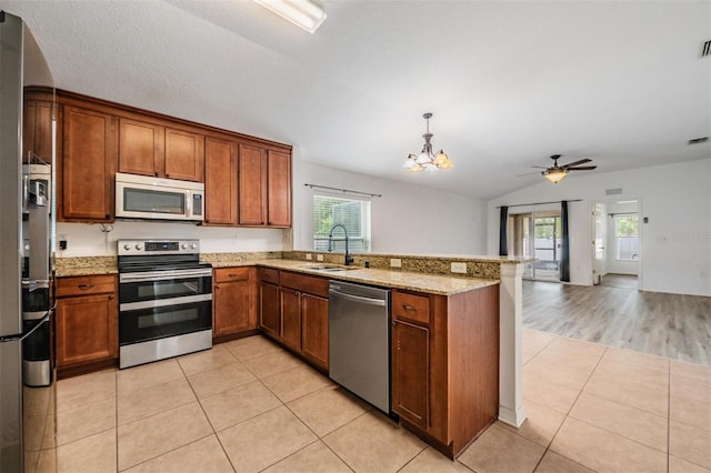 kitchen with vaulted ceiling, appliances with stainless steel finishes, sink, and a healthy amount of sunlight