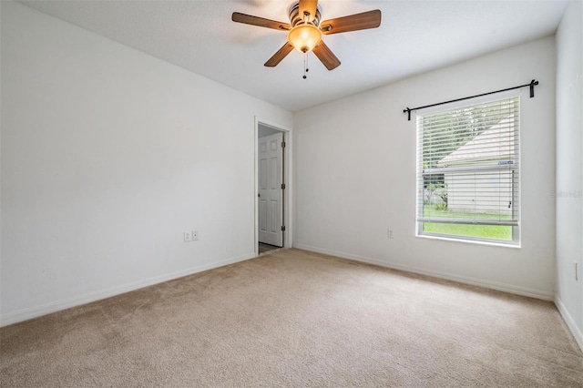 carpeted spare room with ceiling fan