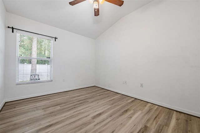 empty room with ceiling fan, lofted ceiling, and light hardwood / wood-style floors