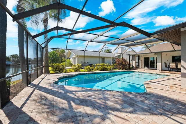 view of swimming pool with a patio, a lanai, and a water view