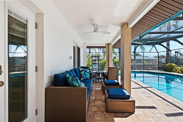 view of swimming pool featuring outdoor lounge area, ceiling fan, a patio, and a lanai