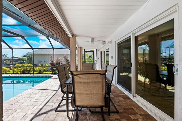 exterior space featuring a patio, glass enclosure, and ceiling fan