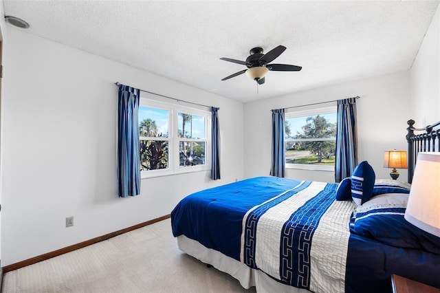 bedroom with ceiling fan, a textured ceiling, and multiple windows