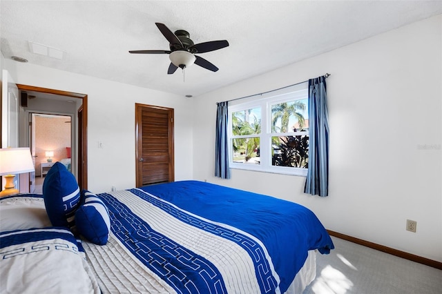 bedroom with a textured ceiling, carpet flooring, and ceiling fan