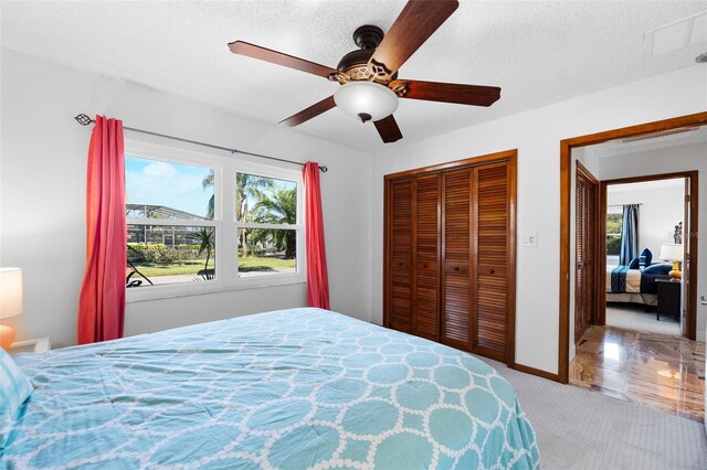 bedroom with ceiling fan, a textured ceiling, and tile patterned flooring