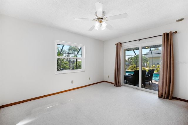 carpeted empty room with a textured ceiling and ceiling fan