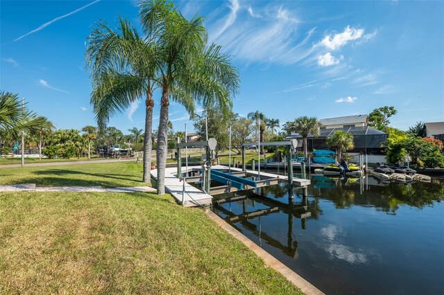 view of dock with a yard and a water view