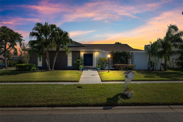 single story home with a lawn