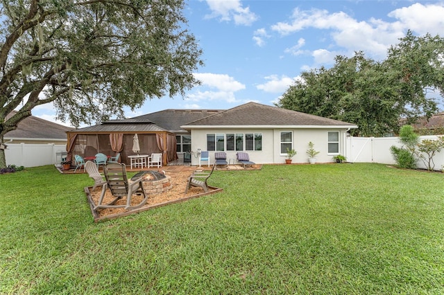 rear view of house featuring an outdoor fire pit, a gazebo, a patio, and a lawn