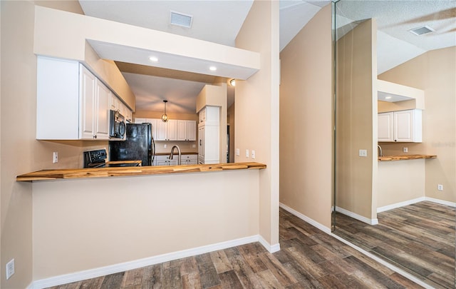 kitchen with kitchen peninsula, white cabinets, lofted ceiling, and black appliances