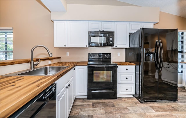 kitchen featuring butcher block countertops, white cabinets, and black appliances