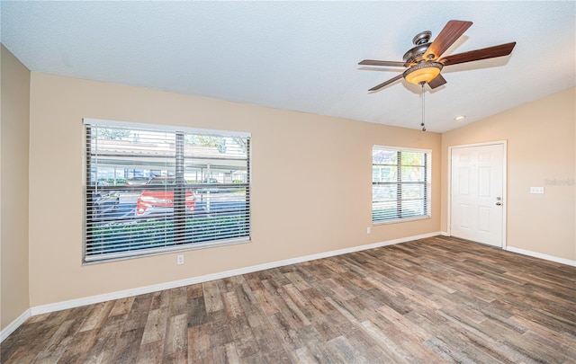 spare room featuring a textured ceiling, ceiling fan, wood-type flooring, and vaulted ceiling