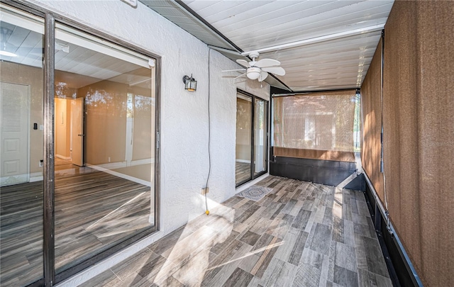 unfurnished sunroom with ceiling fan and wooden ceiling