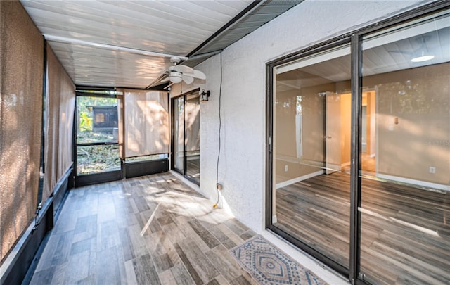 unfurnished sunroom with ceiling fan