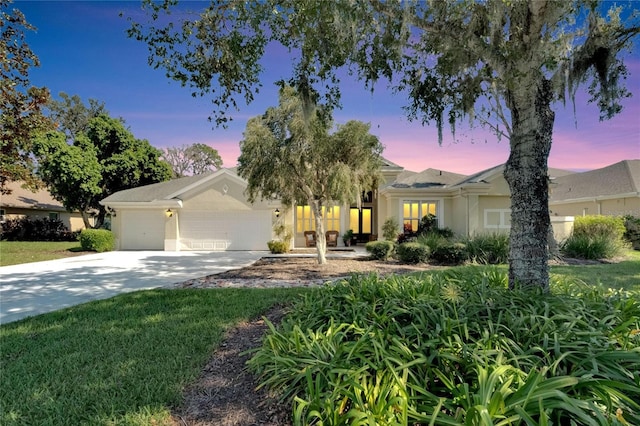 single story home featuring a garage and a yard