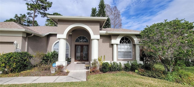 doorway to property with french doors and a lawn