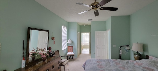 bedroom with light colored carpet, a textured ceiling, and ceiling fan