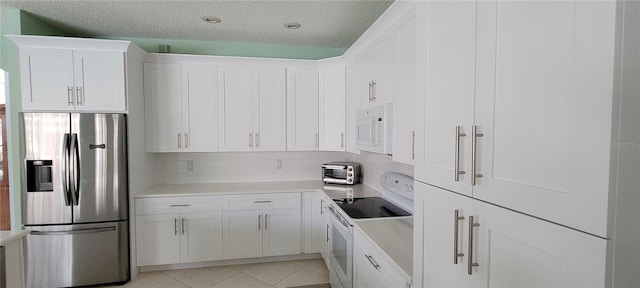 kitchen featuring white appliances, white cabinetry, and a textured ceiling