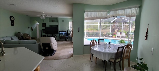 dining room featuring light colored carpet, a textured ceiling, and ceiling fan