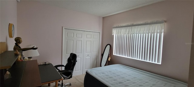 carpeted bedroom featuring a closet and a textured ceiling