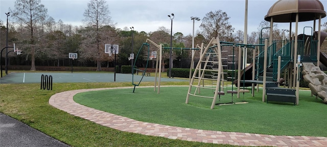 view of playground featuring a lawn and basketball court