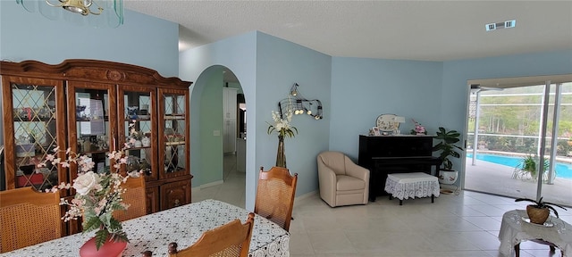 dining space with a textured ceiling and light tile patterned floors