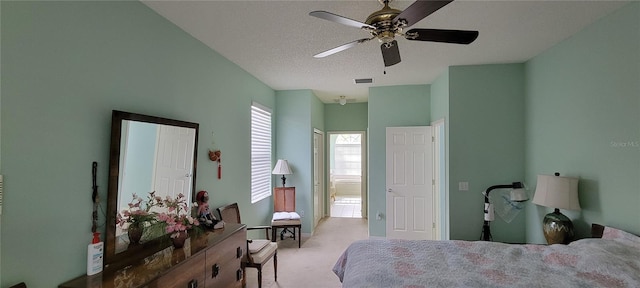 carpeted bedroom with ceiling fan and a textured ceiling