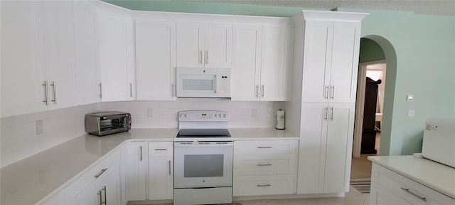 kitchen featuring white cabinetry, white appliances, and decorative backsplash