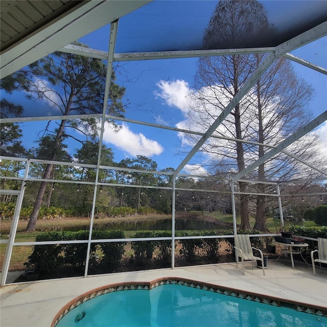 view of pool with a water view, a patio, and a lanai