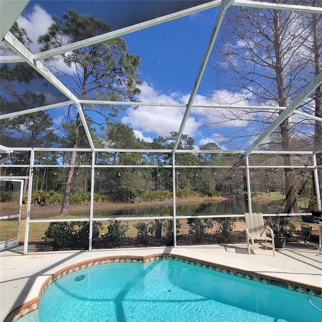 view of swimming pool with a patio, glass enclosure, and a water view