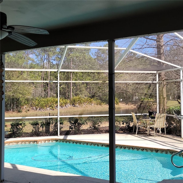 view of swimming pool with a patio area, ceiling fan, and glass enclosure