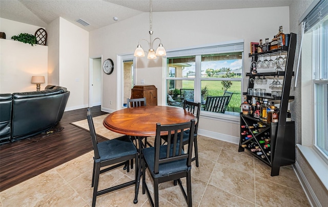 dining area featuring light hardwood / wood-style flooring, an inviting chandelier, lofted ceiling, and a wealth of natural light