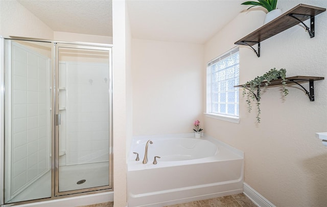 bathroom featuring separate shower and tub and a textured ceiling