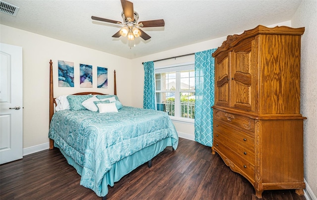 bedroom featuring dark hardwood / wood-style flooring, a textured ceiling, and ceiling fan