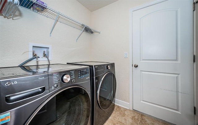 laundry area featuring separate washer and dryer and light tile patterned floors