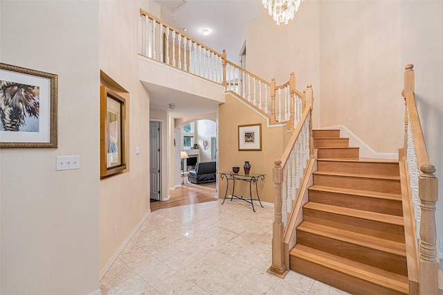 stairs featuring a towering ceiling and hardwood / wood-style floors